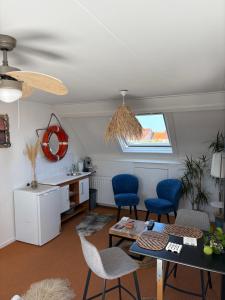 a living room with a table and chairs and a kitchen at PuraVida in Westkapelle