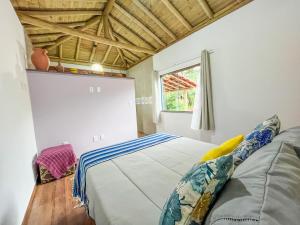 a bedroom with a bed and a window in it at Chalé Flor de Ypê in Carrancas