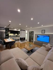 a living room with a couch and a large tv at Residence Stina in Široki Brijeg