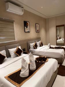 two beds in a hotel room with towels on them at Hotel Liora Suites in Bangalore +177 photos