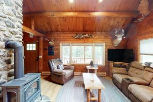 a living room with a fireplace in a log cabin at Wooded Family Retreat! 11 Mi to Acadia Entrance in Trenton