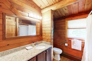 a bathroom with a toilet sink and a mirror at Wooded Family Retreat! 11 Mi to Acadia Entrance in Trenton +20 photos