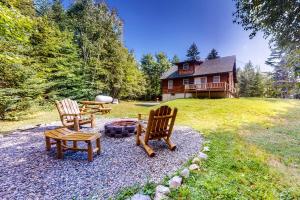 two chairs and a fire pit in front of a house at Wooded Family Retreat! 11 Mi to Acadia Entrance in Trenton