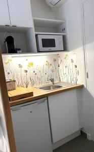a kitchen with a counter with flowers on the wall at Beatrice et Emmanuel Meublé Eiffel in Paris +35 photos