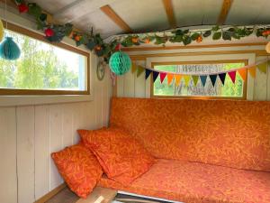 an orange couch in a room with a window and flags at Bel Esprit - Chambres d'hôtes in Kalhausen +110 photos