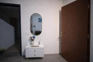 a room with a mirror and a vase of flowers on a table at Casa Nicole in Assemini