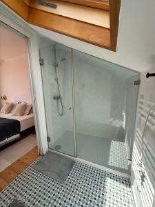 a glass shower in a room with a bedroom at Suite privativa em apartamento em Algés, Lisboa in Algés