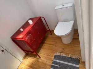 a bathroom with a red cabinet next to a toilet at Suite privativa em apartamento em Algés, Lisboa in Algés +2 photos