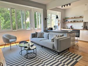 a living room with a couch and a kitchen at Suite privativa em apartamento em Algés, Lisboa in Algés