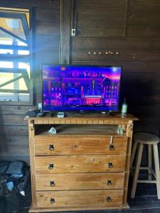 a tv on top of a wooden dresser at Casa Buddha in Imbituba