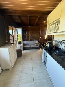 a kitchen and living room with a couch in the background at Casa Buddha in Imbituba