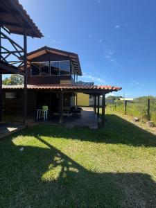 a house with a roof on top of the grass at Casa Buddha in Imbituba