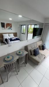 a living room with a table and a couch at Mana Experience Muro Alto in Porto De Galinhas +26 photos