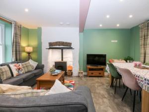 a living room with a couch and a fireplace at Tregynrig Bach in Cemaes Bay