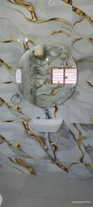 a bathroom with a sink and a mirror on the floor at Santhosh Villa in Thanjāvūr