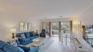 a living room with a blue couch and a table at Atlantic Breeze #5 in Jekyll Island