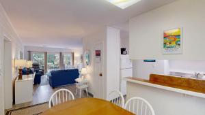 a kitchen and living room with a table and chairs at Atlantic Breeze #5 in Jekyll Island