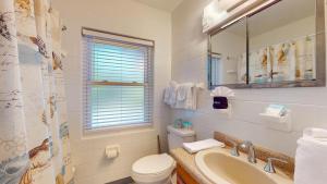 a bathroom with a sink and a toilet and a mirror at Atlantic Breeze #5 in Jekyll Island +12 photos