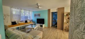 a living room with a couch and a television at Escale caraibe in Le Gosier