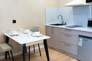a small kitchen with a white table and chairs at Мегаполис in Astana