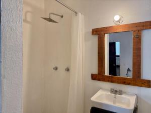 a bathroom with a sink and a mirror at Casa OMI in Brisas de Zicatela