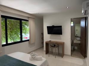 a bedroom with a bed and a tv and a bathroom at Arcadia Hotel in Cartagena de Indias