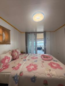 a bedroom with a large bed with flowers on it at Kaneng Homestaykohpu in Ban Klang