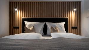 a bedroom with a large bed with white pillows at Naturhaus Leger in Lenggries +20 photos
