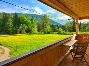 a porch with a bench and a view of a field at Naturhaus Leger in Lenggries
