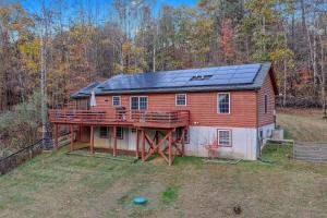 a large red barn with solar panels on it at Creekview Cabin - Hot Tub, EV Station, Pet Friendly, Screen Porch, Wifi, Grill, Fire Pit, Deck, Family Friendly, Game Room, King Bed in Morton Grove