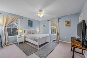a bedroom with a bed and two windows at Creekview Cabin - Hot Tub, EV Station, Pet Friendly, Screen Porch, Wifi, Grill, Fire Pit, Deck, Family Friendly, Game Room, King Bed in Morton Grove