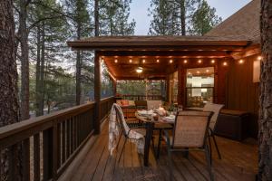 a screened porch with a table and chairs on a deck at Cozy Chalet in the Pines in Munds Park