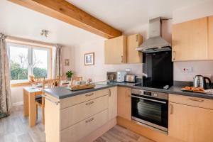 a kitchen with wooden cabinets and a stove top oven at 2 Bed in Duns oc-c34024 in Duns