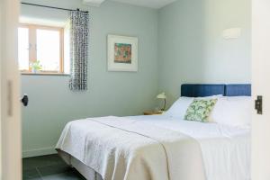 a bedroom with a large white bed with a window at 3 Bed in Loddiswell oc-t34185 in Churchstow