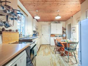 a kitchen with a wooden ceiling and a table with chairs at 4 Bed in Lower Bockhampton oc-t34129 in West Stafford