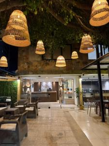 a restaurant with tables and chairs and chandeliers at Arcadia Hotel in Cartagena de Indias