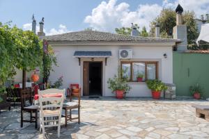 a small white house with chairs and a patio at Stefania's Houses in Zagora