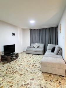 a living room with two couches and a flat screen tv at Casa Altamirano in Chilpancingo de los Bravos