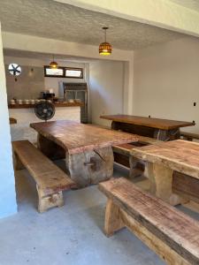 a large room with wooden tables and benches at Tupinambá Pousada e Hostel in Caraíva