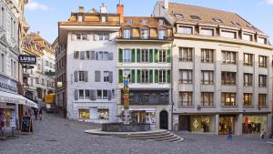 a city street with buildings and a fountain in the middle at Bistro Walk Apartment in Lausanne