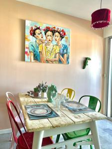 a dining room table with a painting on the wall at Sète en couleurs in Sète