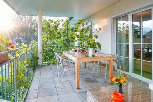 a patio with a wooden table and chairs on a balcony at Coraline -Koblach, 6-10 P, 3 Schlafzimmer, Küche, riesige Terrasse, Parkplatz, WiFi, Stellplatz Ski in Koblach
