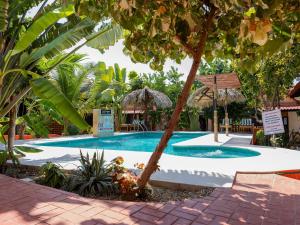 a swimming pool in a resort with trees at Las Barracas de la Barra in Malucano