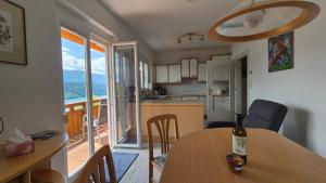 a kitchen and dining room with a table with a bottle of wine at Haus Kraller-Urlaub mit Seeblick in Millstatt
