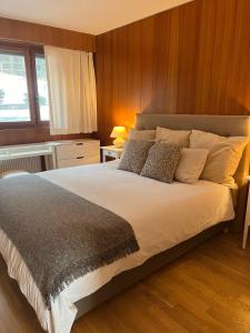 a bedroom with a large bed with wooden walls at Renovated Apartment 5 min to Crans Montana Center in Crans-Montana