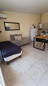 a bedroom with a bed and a table and a desk at Once Reinas Departamentos in San Rafael