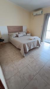 a bedroom with a bed and a tiled floor at Once Reinas Departamentos in San Rafael
