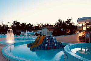 a swimming pool with a water park with a slide at ZEcamping 4 étoiles avec parc aquatique - sauna et hammam in Sanguinet