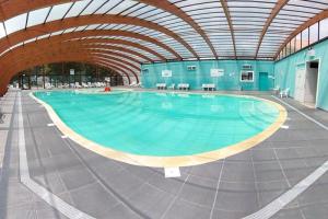 a large swimming pool with a large ceiling at ZEcamping 4 étoiles avec parc aquatique - sauna et hammam in Sanguinet