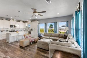 a living room with a couch and a ceiling fan at Steps to the Beach l Modern Interior in Crystal Beach